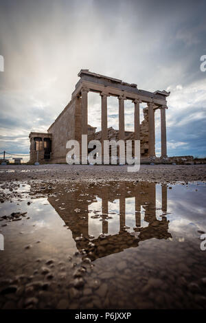 Gamme dynamique élevée photo de Temple d'Athéna dans l'Acropole, vu avec réflexion sur flaque et ciel dramatique. Banque D'Images