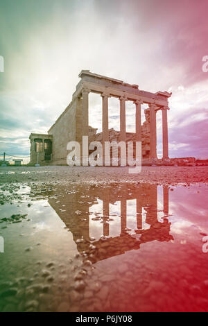 Gamme dynamique élevée photo de Temple d'Athéna dans l'Acropole, vu avec réflexion sur flaque et ciel dramatique. Banque D'Images