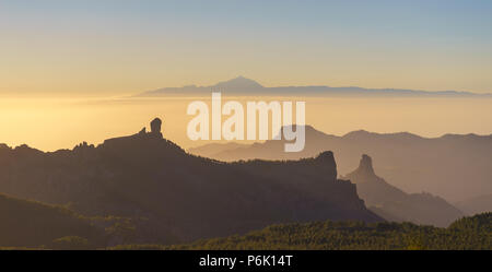 Silhouettes de Roque Nublo et Bentayga contre coucher du soleil la lumière. Pico de Teide sur l'arrière-plan. Gran Canaria, îles Canaries, Espagne Banque D'Images