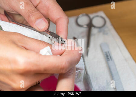 Équipements en Chambre d'appoint. Libre de la manucure, appliquant la cuticule coupe avec des ciseaux. Woman in nail salon receiving manicure par esthéticienne professionnelle Banque D'Images