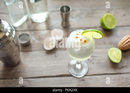 Pisco Sour Cocktail. Mexicains, chiliens, péruviens boisson traditionnelle pisco sour liqueur aux œufs et de lime et le bar matériel pour la préparation. Banque D'Images