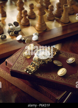 Close-up of antique gold watch et boutons en laiton sur les livres Banque D'Images