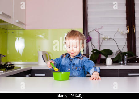 Bébé Enfant consomme des aliments lui-même avec cuillère Banque D'Images