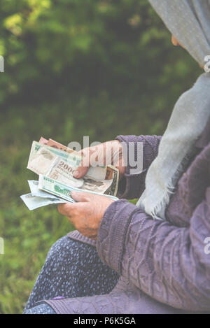 La vieille femme considère billets - mains et de l'argent fermer Banque D'Images