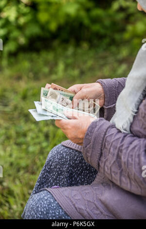 La vieille femme considère billets - mains et de l'argent fermer Banque D'Images