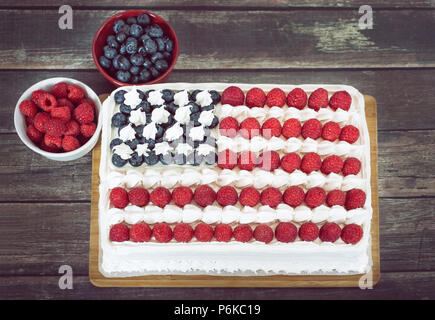 Patriotique, rouge blanc et bleu, le drapeau américain, gâteau décoré avec des bleuets et framboises. Vue d'en haut contre la table en bois rustique. Concept pour Fourt Banque D'Images