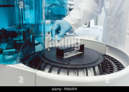 Technicien de laboratoire avec des tubes à centrifuger de chargement du sang humain Banque D'Images