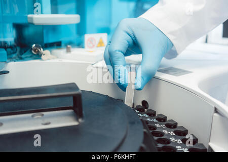 Doctor putting tubes de sang dans la centrifugeuse pour le test Banque D'Images