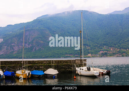 Petit bateau port avec les Alpes en arrière-plan, le lac de Côme à Mandello del Lario. Banque D'Images