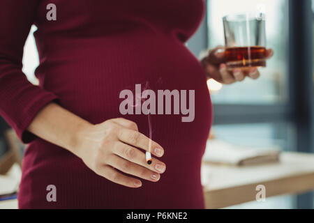 Femme enceinte irresponsable fumer et boire de l'alcool Banque D'Images