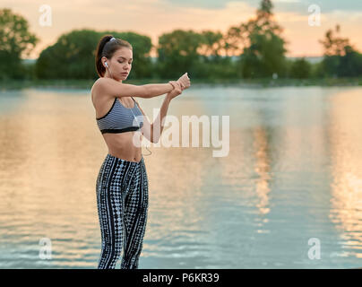 Exercices de sport du soir fit girl en été. Les étirements, yoga, remise en forme. Le maintien du modèle de vie sain, la figure sportive, belle apparence. Avoir joli visage, belle figure. Temps d'été chaud. Banque D'Images