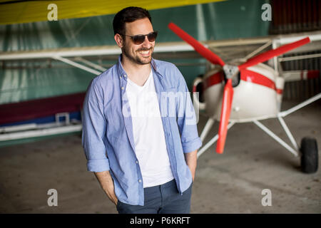 Beau jeune homme dans le hangar avion Banque D'Images