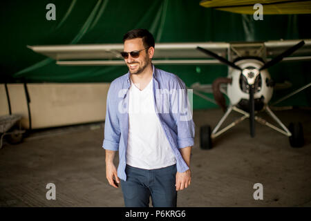 Beau jeune homme dans le hangar avion Banque D'Images