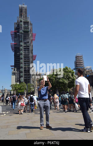 Les touristes et les visiteurs de Londres prendre des photos avec des téléphones mobiles, Ipad et tablettes à Westminster devant les Maisons du Parlement, où de grands Banque D'Images