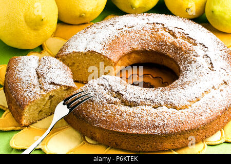 Angel food cake en tranches avec la fourchette d'argent et de citrons Banque D'Images