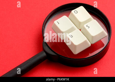 Emploi de mots faite avec les touches du clavier blanc placé sur la lentille loupe contre fond rouge Banque D'Images