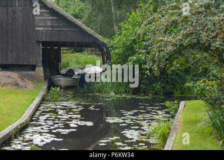 Boat House couvrant les bateaux dans petit canal Banque D'Images