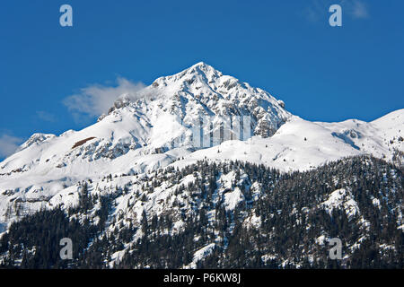 Paysage d'hiver avec la montagne enneigée contre ciel bleu clair Banque D'Images