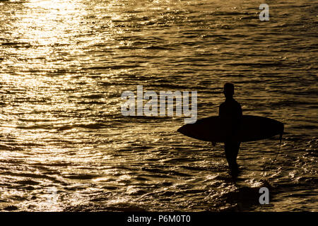 Silhouette de surfeur sur la plage, par la mer à Ipanema, Rio de Janeiro pendant le coucher du soleil Banque D'Images