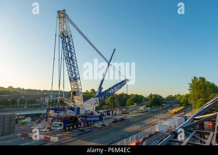 La gare centrale de Telford, Telford, Shropshire, Angleterre, dimanche 1er juillet 2018. L'un des plus grands ascenseurs grues mobiles une nouvelle section de la passerelle de fer en place sur la ligne de chemin de fer à côté de l'A442 Queensway Road, Telford. Le 95 tonnes Grue mobile Liebherr LG1750 lifed la première traversée de l'article sur c'est montable dans les premières heures du matin le dimanche 1er juillet 2018. Les projets de génie civil est le remplacement de la passerelle d'origine à un coût d'environ 10 millions de livres. Credit : AMD Images/Alamy Live News Banque D'Images