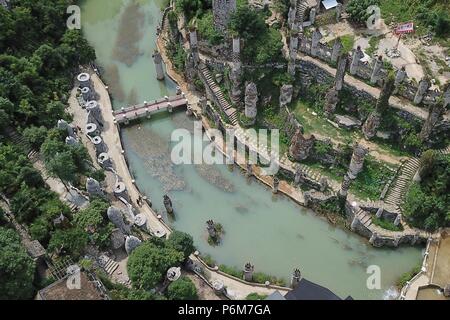 (180701) -- GUIYANG, 1 juillet 2018 (Xinhua) -- photo aérienne prise le 1 juillet 2018 montre une vue générale du château de pierre chanson Peilun' dans 'Yelang Leping Village de Huaxi District à Guiyang, dans le sud-ouest de la province du Guizhou en Chine. Chanson a renoncé à l'occasion de demeurer aux États-Unis en tant que caricaturiste. Au lieu de cela, il est retourné à une parcelle de terre en friche dans sa province de Guizhou. Là, il a décidé de créer un genre différent d'art. Le parc du château sont le foyer de plus de 300 statues bordant les deux côtés d'un ruisseau. Elles ressemblent à l'énorme des personnages humains sur l'île de Pâques. S'inspirant de la chanson Banque D'Images