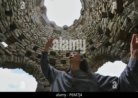 (180701) -- GUIYANG, 1 juillet 2018 (Xinhua) -- Chanson Peilun introduit l'inspiration de son château en pierre' dans 'Yelang Leping Village de Huaxi District à Guiyang, dans la province du Guizhou en Chine du sud-ouest, 1 juillet 2018. Chanson a renoncé à l'occasion de demeurer aux États-Unis en tant que caricaturiste. Au lieu de cela, il est retourné à une parcelle de terre en friche dans sa province de Guizhou. Là, il a décidé de créer un genre différent d'art. Le parc du château sont le foyer de plus de 300 statues bordant les deux côtés d'un ruisseau. Elles ressemblent à l'énorme des personnages humains sur l'île de Pâques. Chanson s'inspire de Nuo local o Banque D'Images