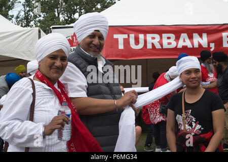 Calgary, Canada. 1er juillet 2018. Femme est liée au turban Turban, Eh ?, un événement organisé par la World Sikh Organization au Prince's Island Park sur la fête du Canada. Les gens ont été invités à avoir une couleur rouge ou turban blanc enroulé autour de leur tête et en apprendre davantage sur la culture Sikh. Rosanne Tackaberry/Alamy Live News Banque D'Images