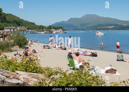 Plage de Luss, Loch Lomond et Ben Lomond occupé par une chaude journée d'été, Ecosse, Royaume-Uni Banque D'Images