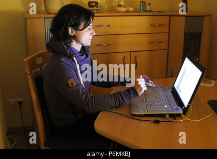 Melbeck, Allemagne - femme est assise devant son ordinateur portable Banque D'Images