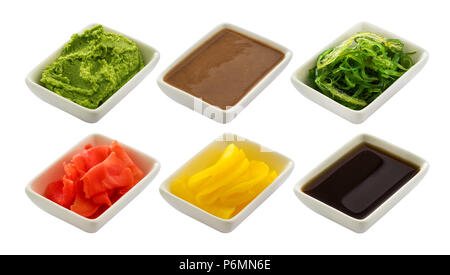 Condiment japonais pour sushi. Sauce soja, wasabi, gingembre mariné, chuka, sauce sésame et radis marinés isolé sur fond blanc Banque D'Images