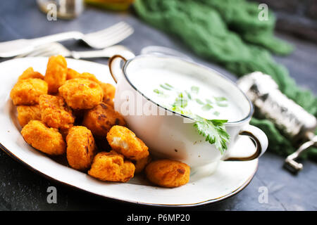 Poêlée de poulet popcorn couvert d'Ariane sur la plaque avec la sauce Banque D'Images