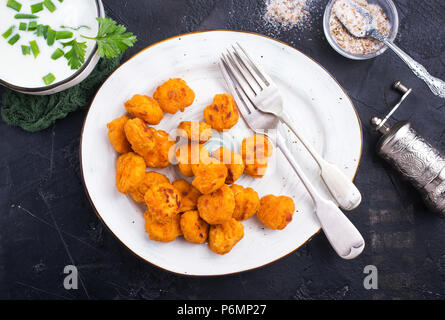 Poêlée de poulet popcorn couvert d'Ariane sur la plaque avec la sauce Banque D'Images