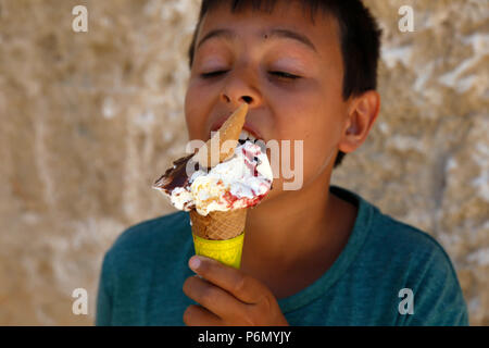 Garçon de 11 ans de manger une glace dans le Salento, Italie. Banque D'Images