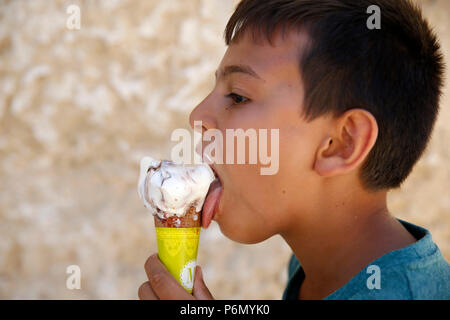 Garçon de 11 ans de manger une glace dans le Salento, Italie. Banque D'Images