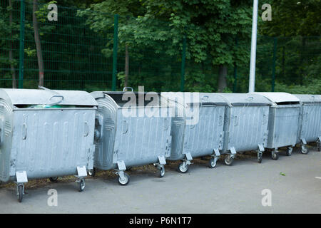 Grand métal rempli des poubelles sur la rue standing in a row Banque D'Images