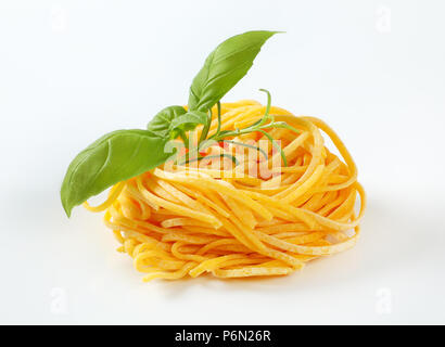 Paquet de pâtes spaghetti aux herbes fraîches sur fond blanc Banque D'Images