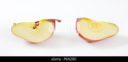 Quartiers de pomme rouge sur fond blanc Banque D'Images
