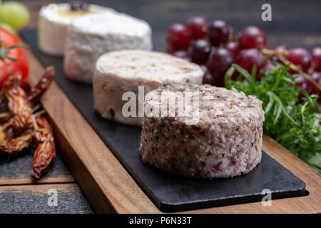 Les fromages français, variété de goûts différents fromages de lait de chèvre sur la plaque de granit naturel fermer jusqu'sesrved comme dessert Banque D'Images