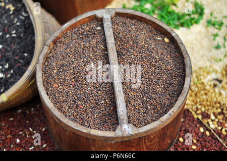 Graines de moutarde, de lin, de tournesol et de coriandre sont déversées à partir de sacs de linge Banque D'Images
