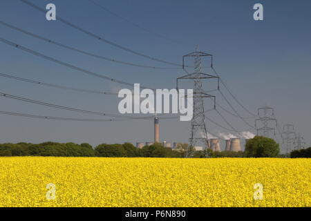 L'huile de colza jaune champ avec pylônes et power station dans l'arrière-plan dans la campagne du Yorkshire Banque D'Images