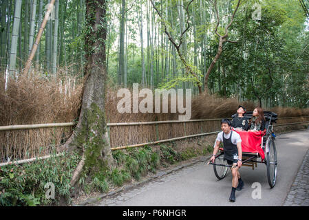 Main traditionnel tiré en pousse-pousse dans des forêts de bambous Sagano Arashiyama, à la périphérie de Kyoto, au Japon. Banque D'Images