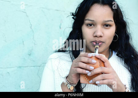 Portrait de jeune femme latine boire du maté argentin traditionnel thé. Boisson populaire d'Amérique du Sud. À l'extérieur Banque D'Images