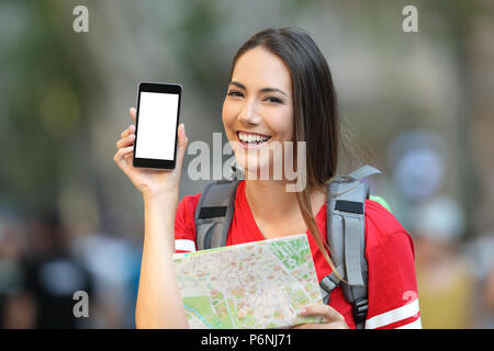 Happy teen'montrant un écran du téléphone mobile dans la rue Banque D'Images