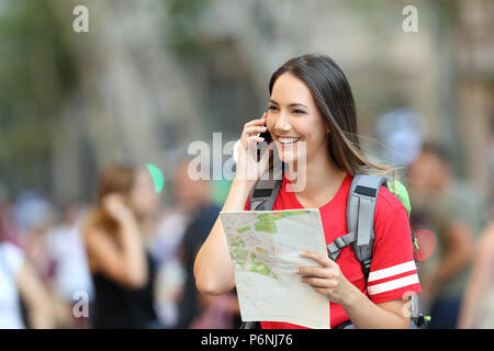 Happy teen'parlant au téléphone la tenue d'un site marchant sur la rue Banque D'Images