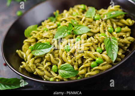 Pâtes Fusilli au pesto, pois verts et basilic. Cuisine italienne. Banque D'Images