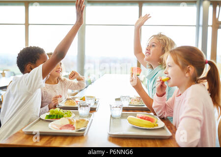 Groupe d'enfants à la cantine en train de déjeuner ou petit-déjeuner s'amusent Banque D'Images