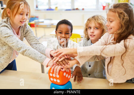 Pile dans les mains des enfants de l'école multiculturelle comme un exercice d'intégration Banque D'Images