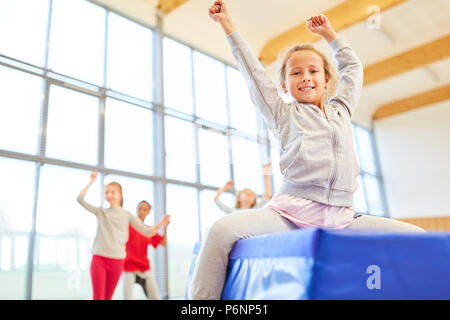 Les filles à l'école élémentaire l'éducation physique s'amusent à faire la gymnastique Banque D'Images