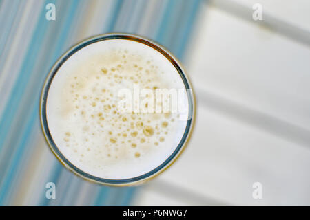 Vue de dessus d'une tasse mousseuse de bière froide sur une chaude journée d'été dans un restaurant en bord de mer Banque D'Images