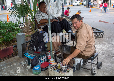 Mérida, Yucatan, Mexique, Un homme mexicain qui polit les chaussures d'un client. Editorial uniquement. Banque D'Images